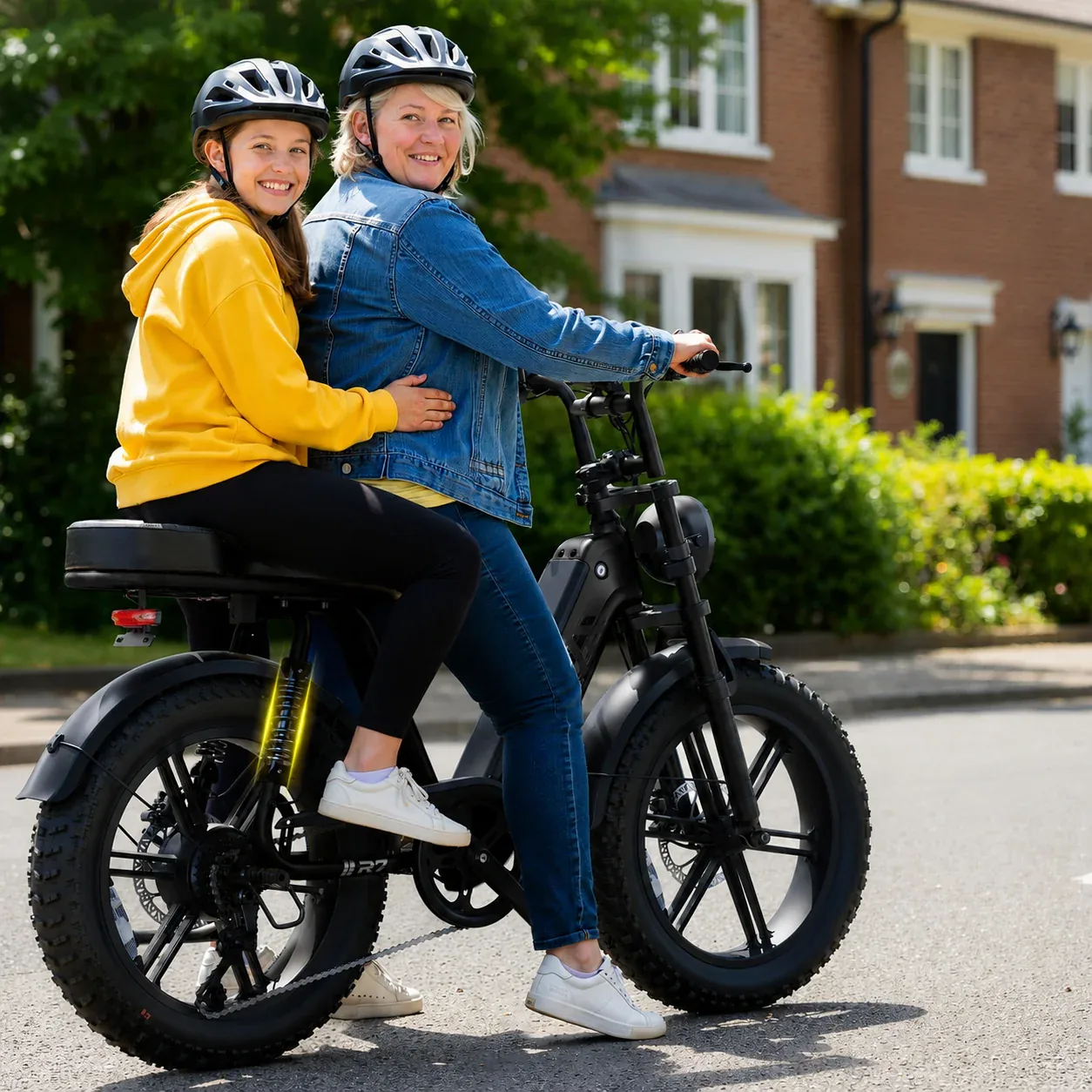 Two riders on a Calder electric bike on a suburban street